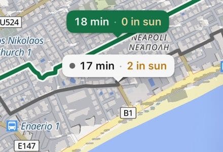 The Shadeway map: building shadows turning as the hour moves from morning to evening, then two walking routes side by side, the app labelling the shaded one 18 min with 0 in sun and the direct one 17 min with 2 in sun.
