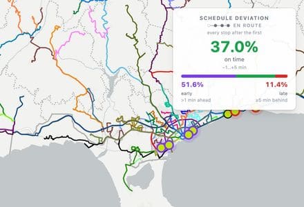 Buses moving along the Limassol coast on the TransitPrism map, coloured route threads behind them, with the product schedule-deviation panel appearing over the map.